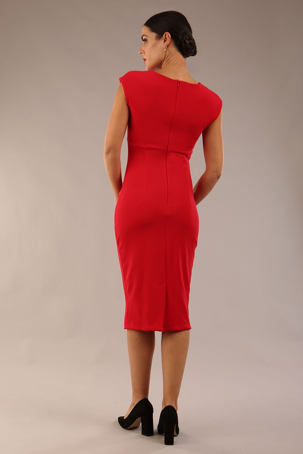 brunette model wearing diva catwalk lydia sleeveless pencil flattering fitted plain dress with split neckline and pleating across the body true red back