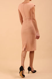 brunette model wearing diva catwalk lydia sleeveless pencil flattering fitted plain dress with split neckline and pleating across the body Almond Mousse back