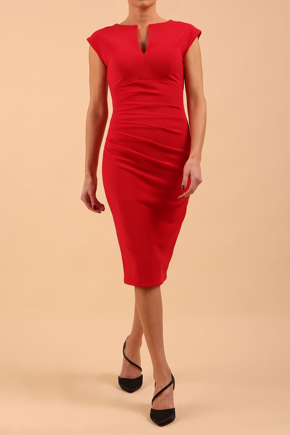 brunette model wearing diva catwalk lydia sleeveless pencil flattering fitted plain dress with split neckline and pleating across the body true red front