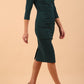 model wearing Diva Catwalk pencil three quarter sleeve dress with a split neckline and pleating across the tummy in green gables front side