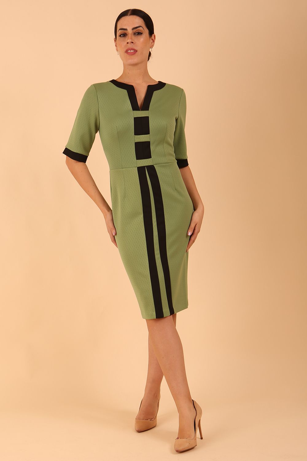 brunette model wearing Diva catwalk goggle pencil dress with short sleeve and v-neckline with contrasted design across body in radiant yellow front