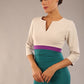 brunette model wearing seed lara pencil colour block dress three quarter sleeve and pleating across the body with split neckline in Pacific green and sandy cream and amethyst purple front