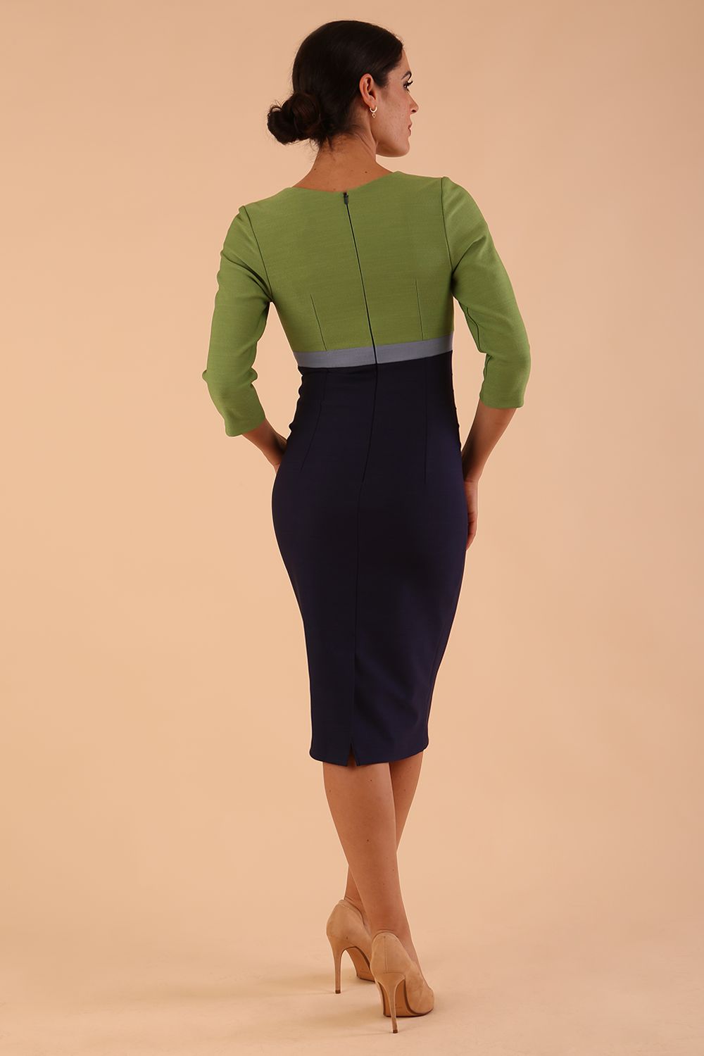 brunette model wearing seed lara pencil colour block dress three quarter sleeve and pleating across the body with split neckline in navy blue and citrus green and sky grey front
