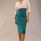 brunette model wearing seed lara pencil colour block dress three quarter sleeve and pleating across the body with split neckline in Pacific green and sandy cream and amethyst purple front