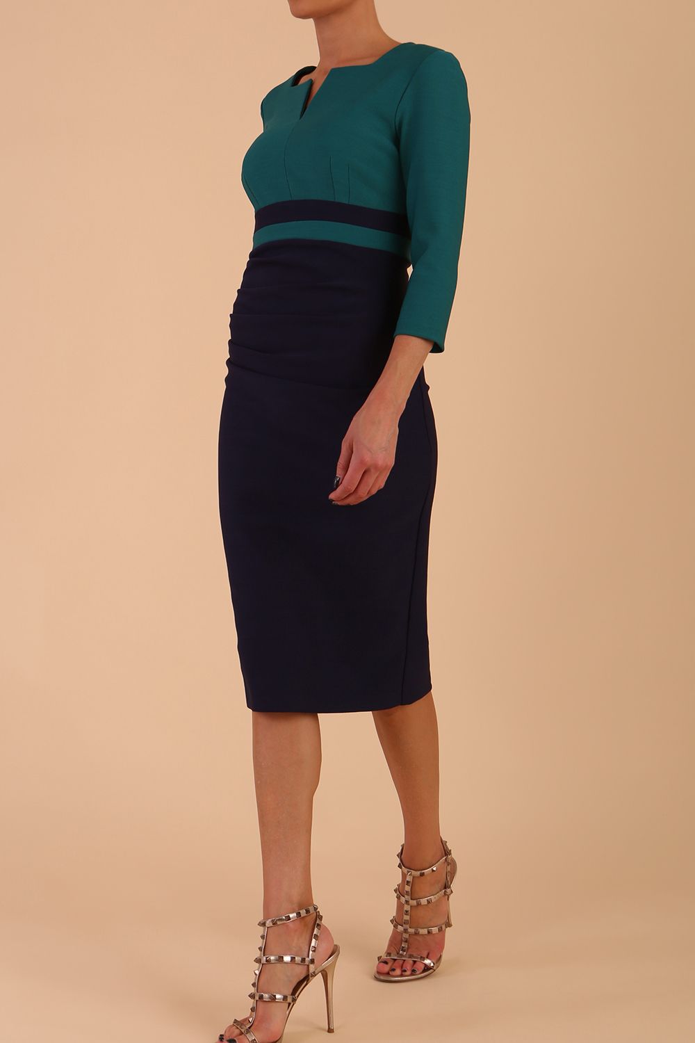 A model is wearing a three quarter sleeve colour block pencil dress by Diva Catwalk in navy and pacific green colour