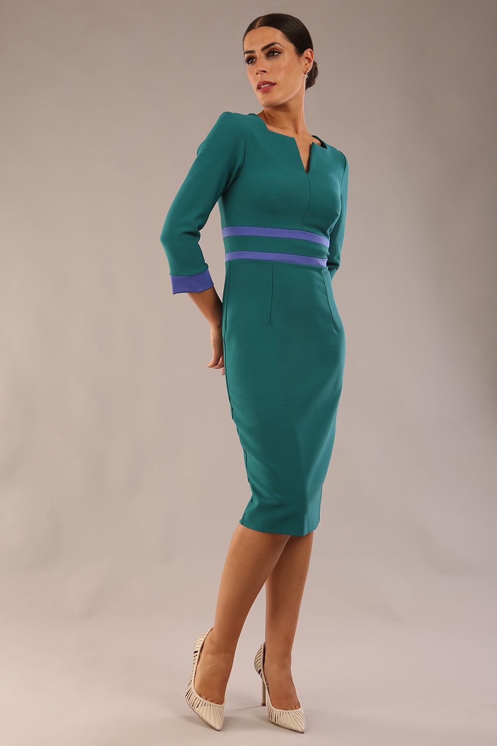 Model wearing Diva catwalk Paeonia dress square neckline with a vent in Pacific Green with Thistle Blue and Pacific Green stripes around the waist and three quarter sleeve with Thistle Blue contrast finish front side