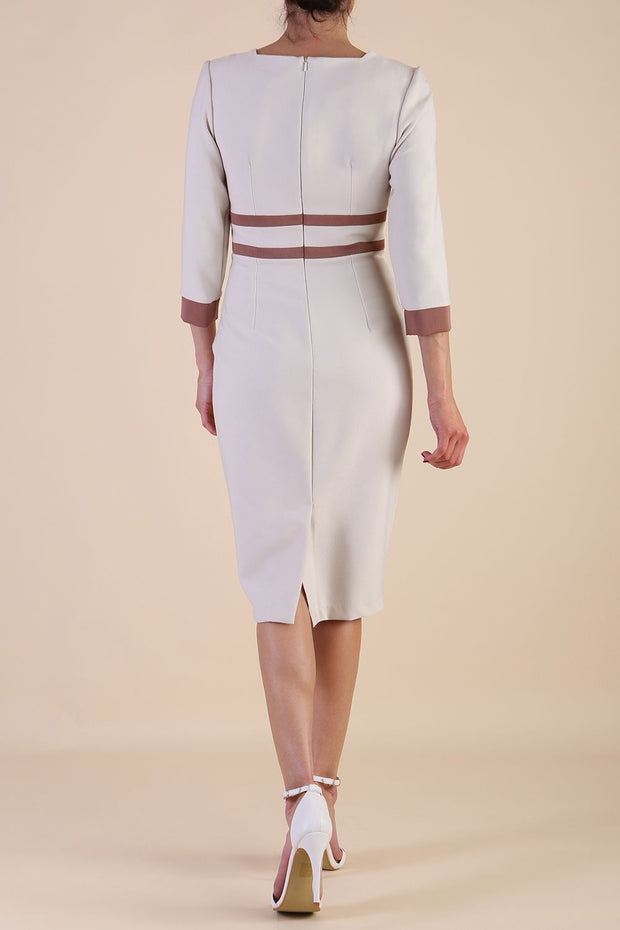brunette model wearing Diva catwalk Paeonia dress square neckline with a vent in sandshell beige with Acorn Brown and sandshell beige stripes around the waist and three quarter sleeve with Acorn Brown contrast finish back