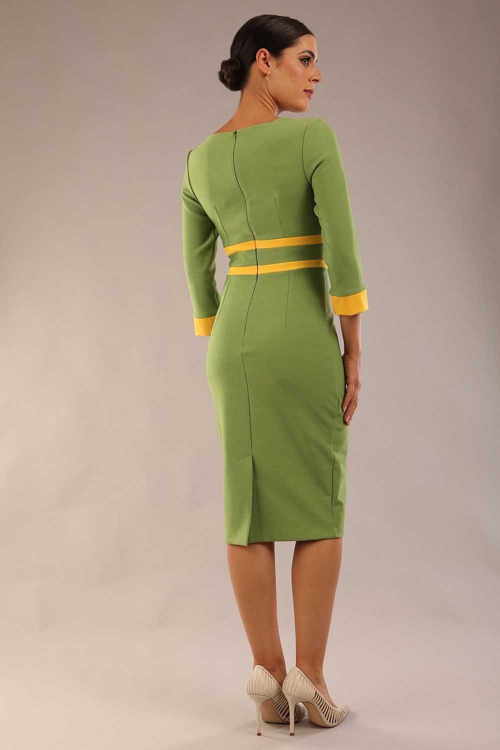 Model wearing Diva catwalk Paeonia dress square neckline with a vent in Citrus Green with Daffodil Yellow and Citrus Green stripes around the waist and three quarter sleeve with Daffodil Yellow contrast finish back