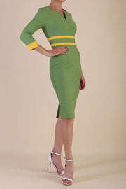 Model wearing Diva catwalk Paeonia dress square neckline with a vent in Citrus Green with Daffodil Yellow and Citrus Green stripes around the waist and three quarter sleeve with Daffodil Yellow contrast finish front