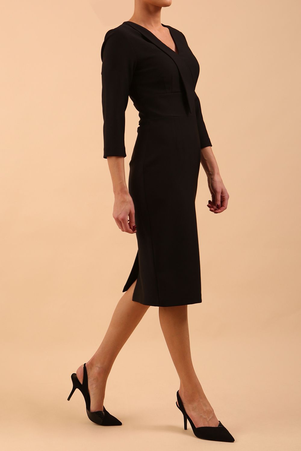 brunette model wearing diva catwalk cranston pencil-skirt dress with low v-neck and tie detail wide band with sleeves in black colour front side