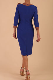 Model wearing Diva catwalk Branwen pencil figure fitted dress in monaco blue with three quarter sleeve and acorn brown bow detail back image