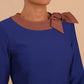 Model wearing Diva catwalk Branwen pencil figure fitted dress in monaco blue with three quarter sleeve and acorn brown bow detail front image