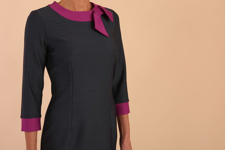 Model wearing Diva catwalk Branwen pencil figure fitted dress in slate grey with three quarter sleeve and dawn purple contrast detail front image detail