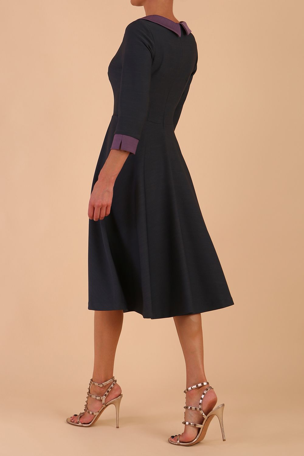 Model wearing Diva catwalk Coralia swing dress in slate grey / dusky lilac contrast with three quarter sleeve figure fitted back image