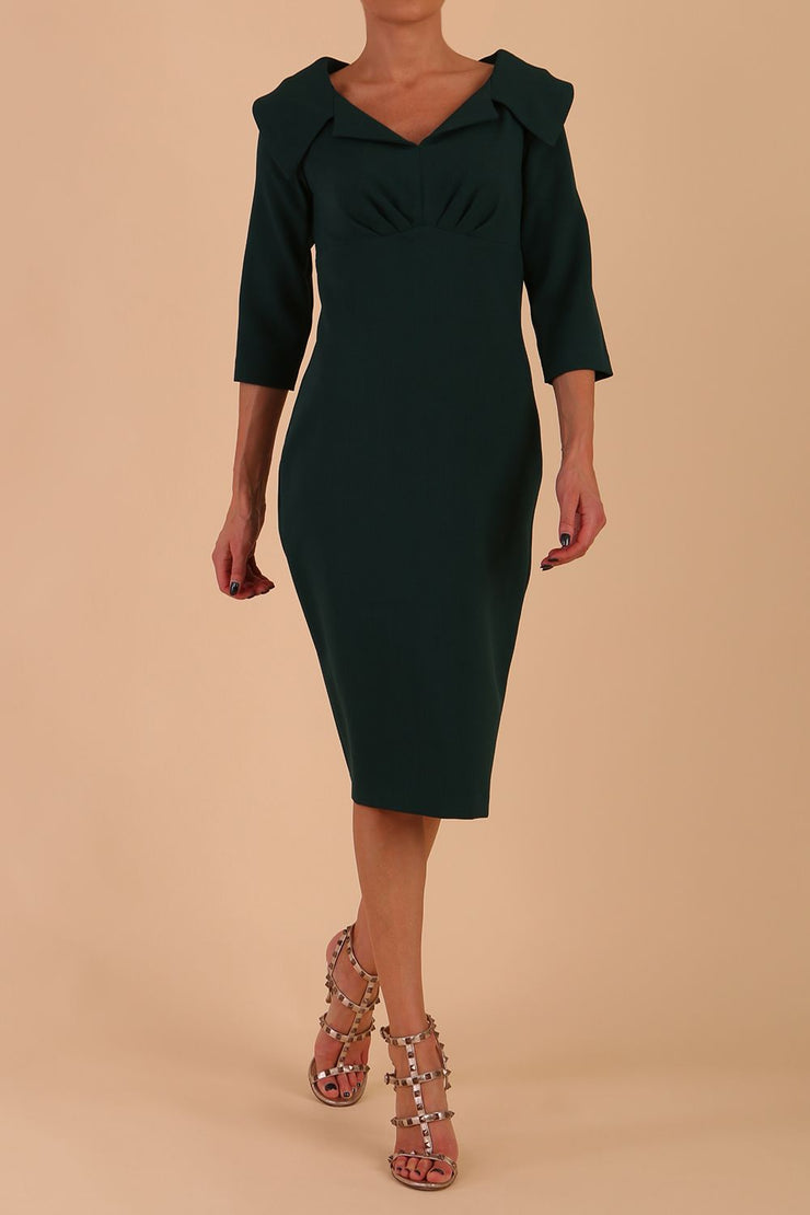 Model wearing Diva catwalk Venetia figure fitted pencil dress in forest green with three quarter sleeve front