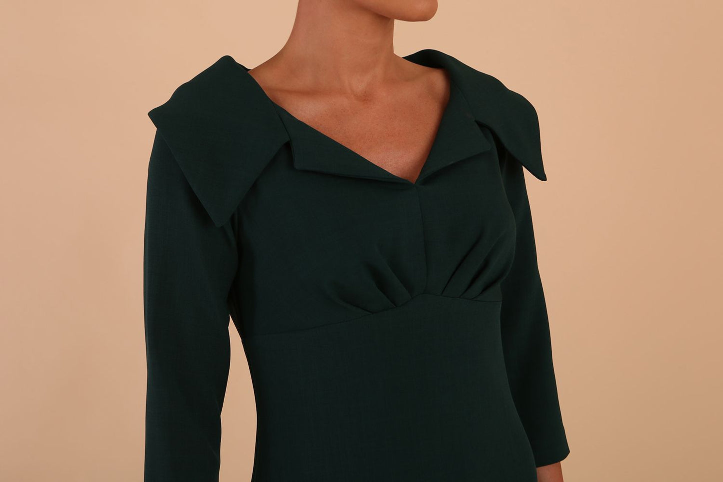 Model wearing Diva catwalk Venetia figure fitted pencil dress in forest green with three quarter sleeve front detail