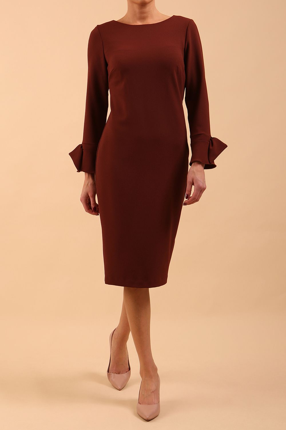 brunette model wearing diva catwalk fitted dress with sleeves called Alma Pencil-skirt dress in colour mahogany brown with bow detail on sleeves front
