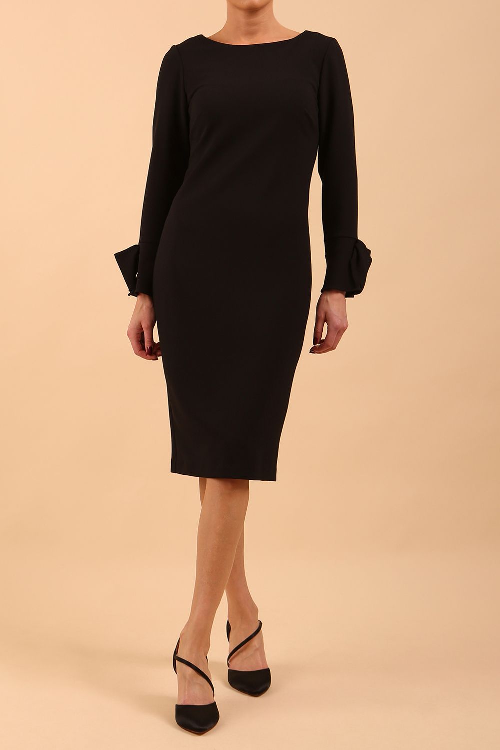 brunette model wearing diva catwalk fitted dress with sleeves called Alma Pencil-skirt dress in colour black with bow detail on sleeves front