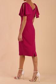brunette model is wearing diva catwalk hermione pencil dress with tie shoulder details and empire waistline in magenta haze back