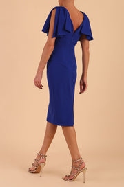 brunette model is wearing diva catwalk hermione pencil dress with tie shoulder details and empire waistline in cobalt blue back side