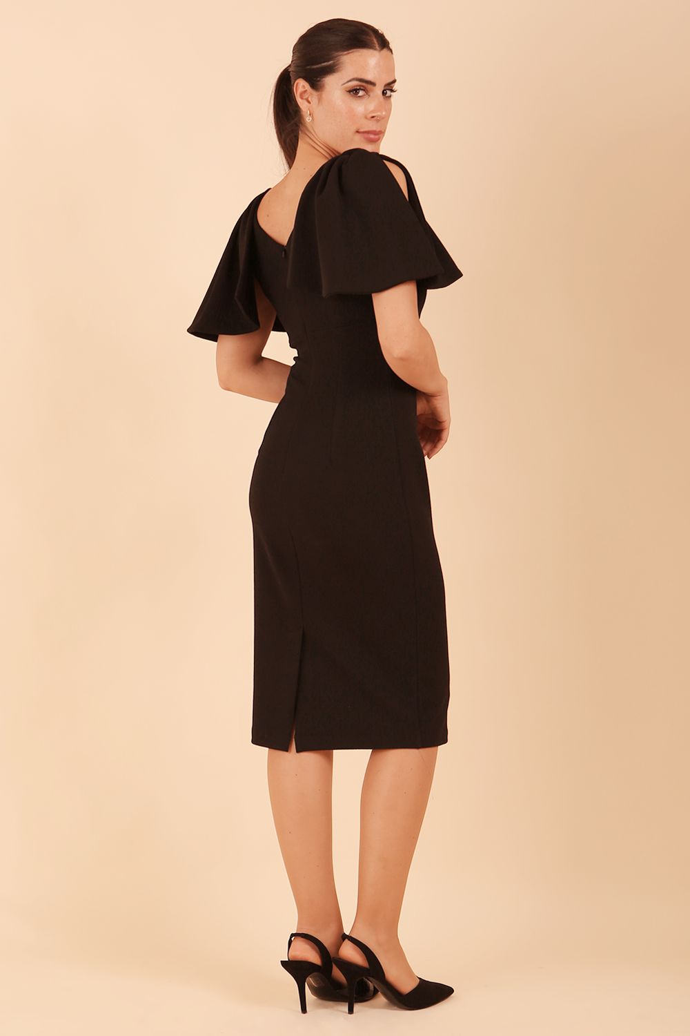 brunette model is wearing diva catwalk hermione pencil dress with tie shoulder details and empire waistline in black back