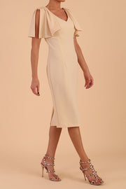 brunette model is wearing diva catwalk hermione pencil dress with tie shoulder details and empire waistline in beige front side