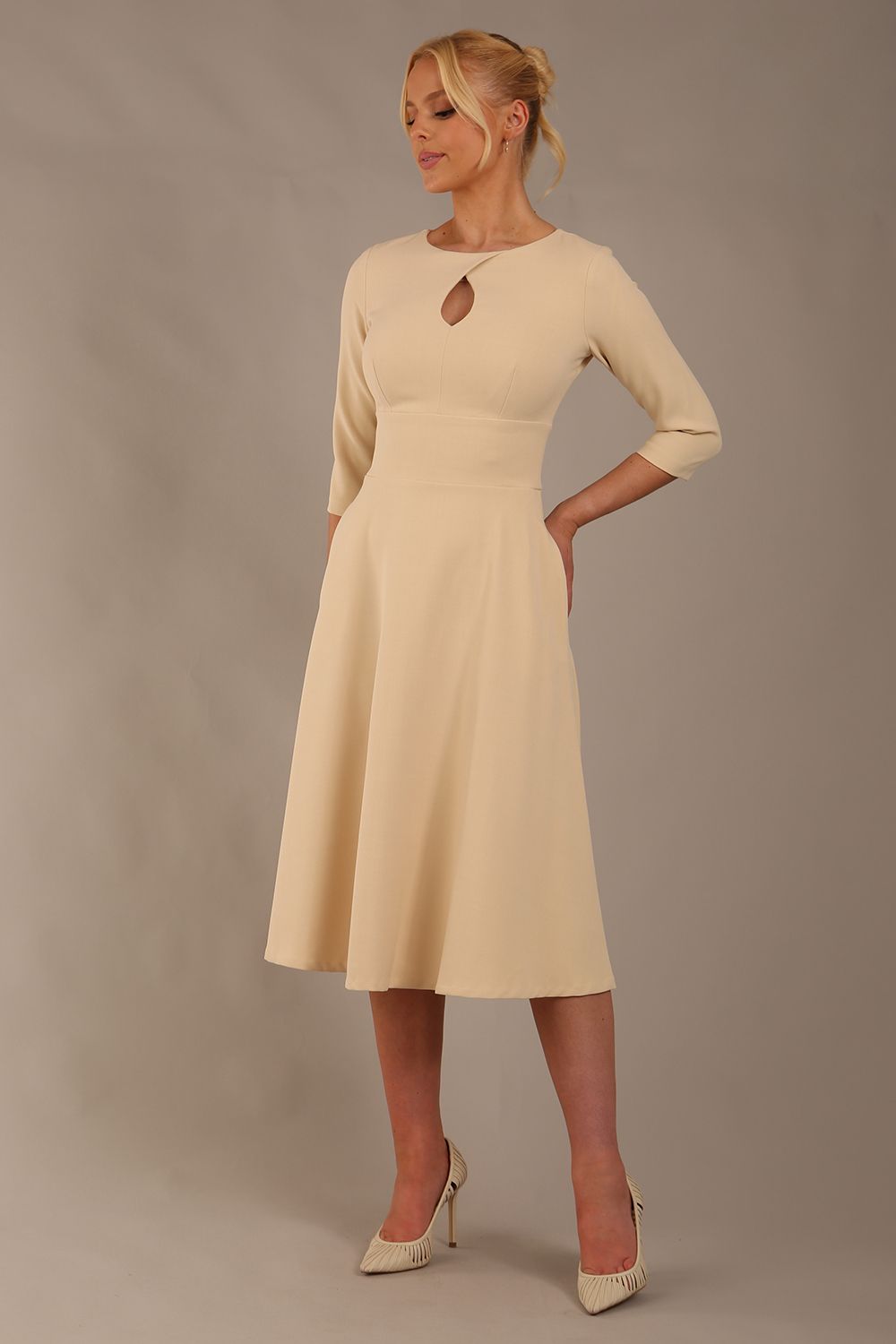 model is wearing diva catwalk casares swing dress with a keyhole neckline three quarter sleeve dress with pocket detail in Sandshell Beige front (Sandshell Beige)