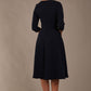  model is wearing diva catwalk casares swing dress with a keyhole neckline three quarter sleeve dress with pocket detail in navy blue back (Navy Blue)