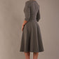 model is wearing diva catwalk casares swing dress with a keyhole neckline three quarter sleeve dress with pocket detail in Castlerock Grey  back side (Castlerock Grey)