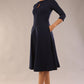 Brunette model is wearing diva catwalk casares swing dress with a keyhole neckline three quarter sleeve dress with pocket detail in navy blue front