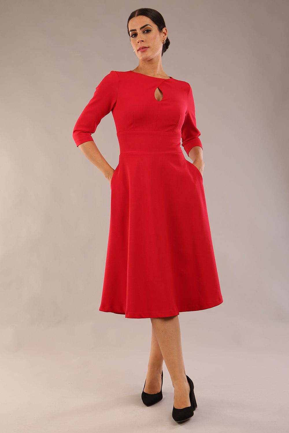 Brunette model is wearing diva catwalk casares swing dress with a keyhole neckline three quarter sleeve dress with pocket detail in red front