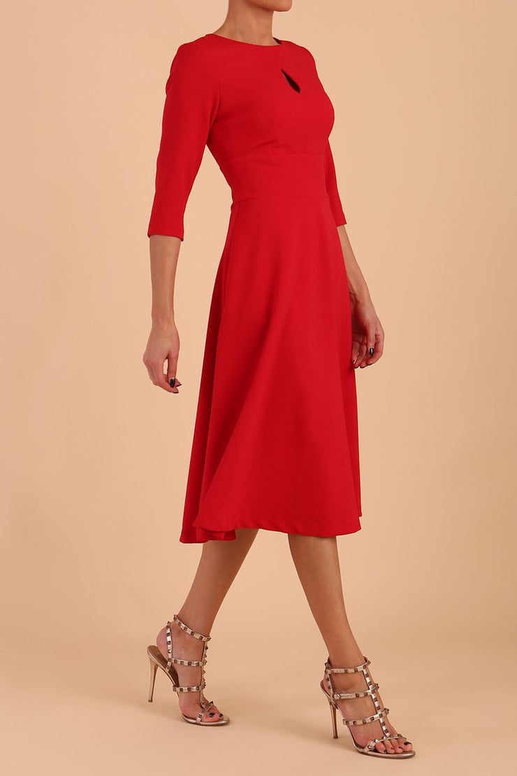 Brunette model is wearing diva catwalk casares swing dress with a keyhole neckline three quarter sleeve dress with pocket detail in Scarlet Red side front