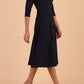 Brunette model is wearing diva catwalk casares swing dress with a keyhole neckline three quarter sleeve dress with pocket detail in Navy side front