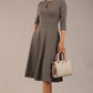 Brunette model is wearing diva catwalk casares swing dress with a keyhole neckline three quarter sleeve dress with pocket detail in Castlerock Grey side front