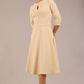 Brunette model is wearing diva catwalk casares swing dress with a keyhole neckline three quarter sleeve dress with pocket detail in Sandshell Beige front