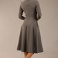Brunette model is wearing diva catwalk casares swing dress with a keyhole neckline three quarter sleeve dress with pocket detail in Castlerock Grey back