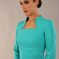 model is wearing diva catwalk plaza sheath dress with high neck Trapezium neckline cutout and three quarter sleeve pretty dress in aqua green front close up