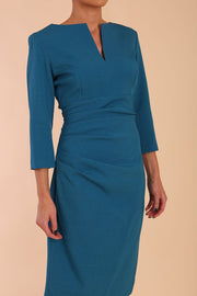 model is wearing diva catwalk chandos sheath dress with three quarter sleeve and slit in the middle of the neckline in teal front