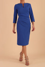 model is wearing diva catwalk chandos sheath dress with three quarter sleeve and slit in the middle of the neckline in cobalt blue front
