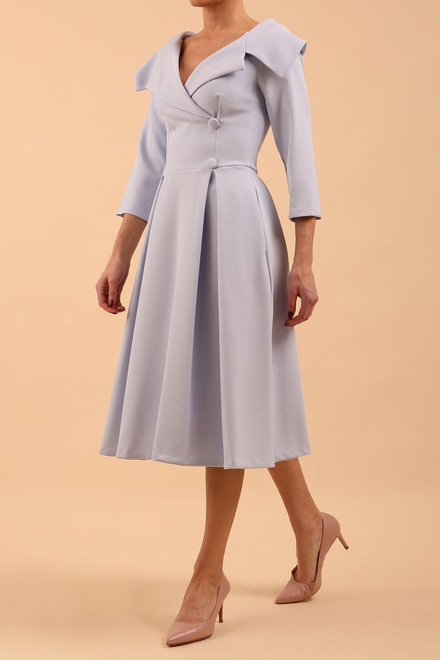 model is wearing diva catwalk gatsby swing dress with pocket detail and wide v-neck collar and buttons down the front panel in celestial blue front