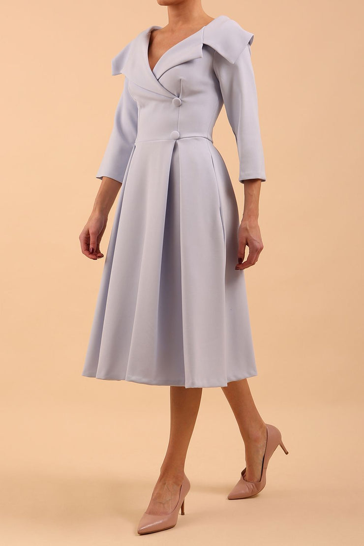 model is wearing diva catwalk gatsby swing dress with pocket detail and wide v-neck collar and buttons down the front panel in celestial blue front