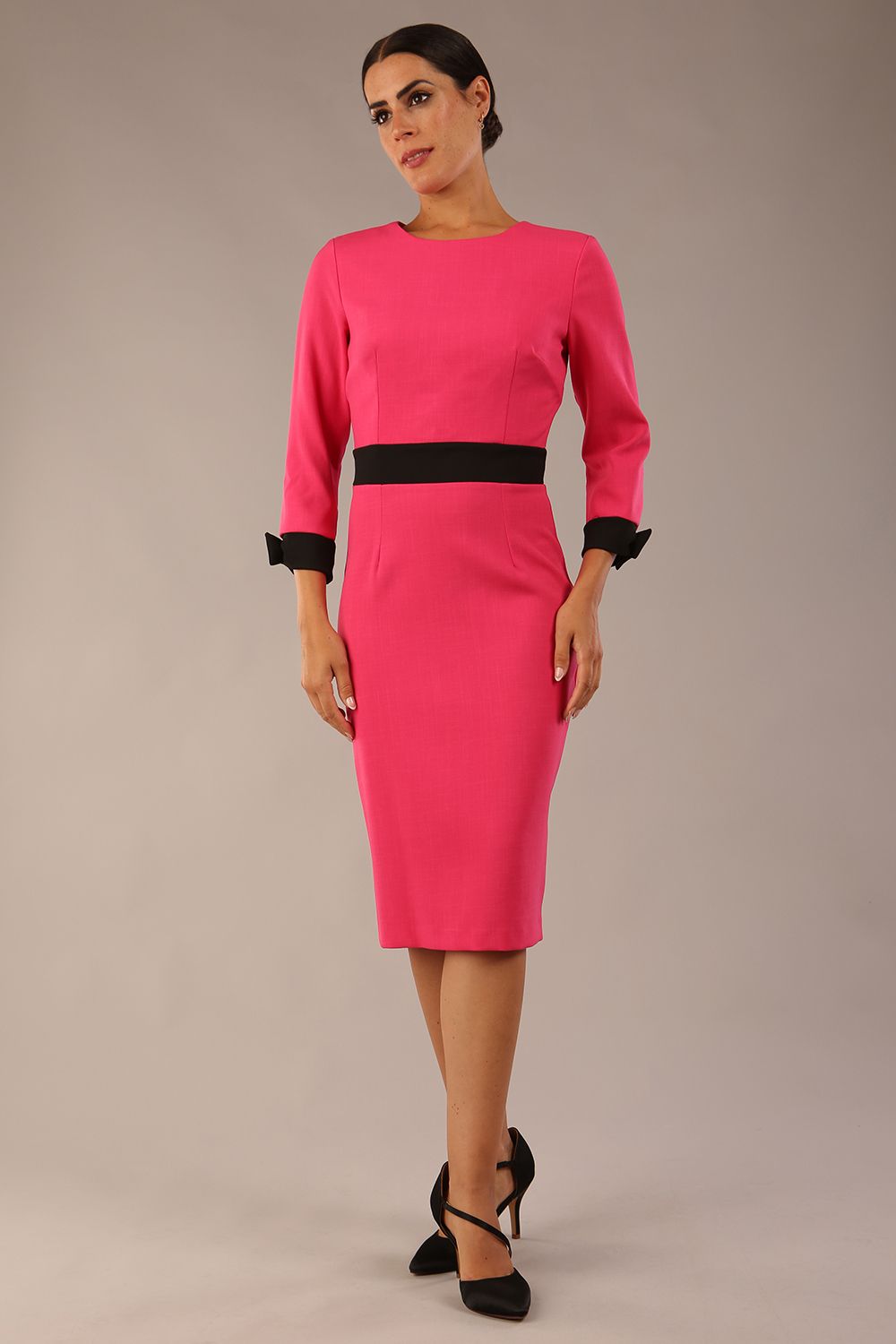 Model wearing diva catwalk Reese 3/4 Sleeved pencil skirt dress with a contrast sleeve and waistband details in Fuschia Pink/Black