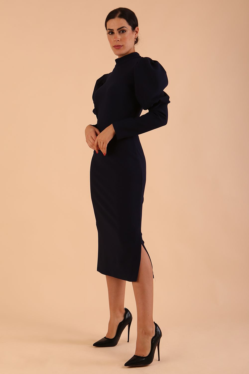 Brunette model wearing a DIVA Catwalk Buffy Puffed Long Sleeve Midi Pencil Dress with high neckline in Navy Blue