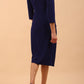 model is wearing diva catwalk liesel wrap pencil sleeved dress with collar half way around low v-neck in oxford blue back