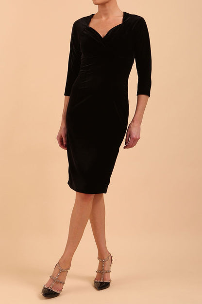 A model is wearing a velvet pencil sweetheart neckline dress by diva catwalk in black