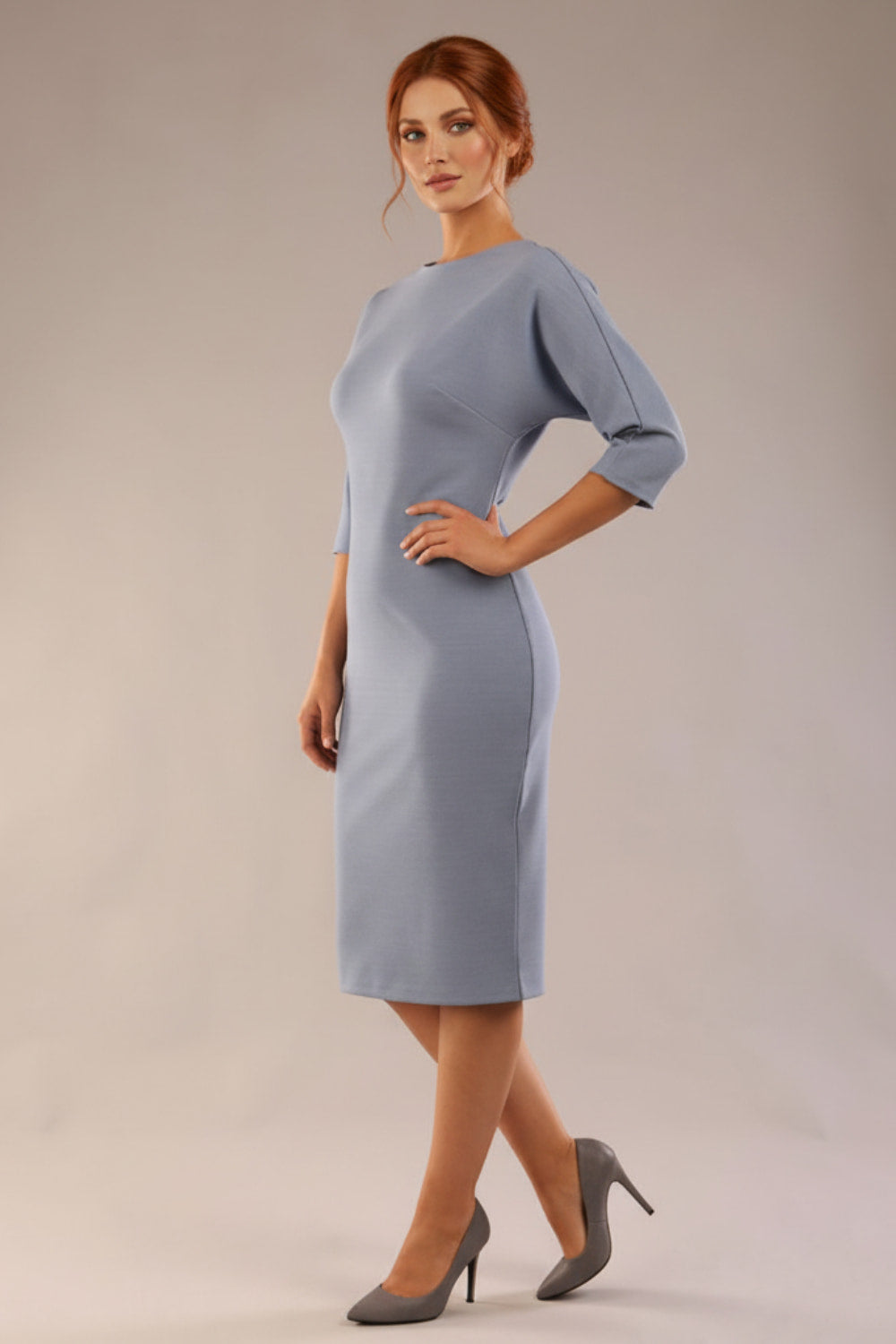 Model wearing the SEED Fulham pencil dress in port royale, showing the clean boat neckline and dolman sleeves (Steel Blue)