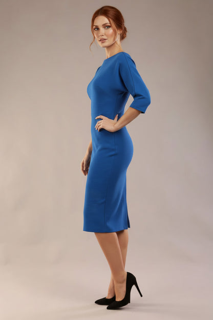 Model wearing the SEED Fulham pencil dress in port royale, showing the clean boat neckline and dolman sleeves (Sapphire Blue)