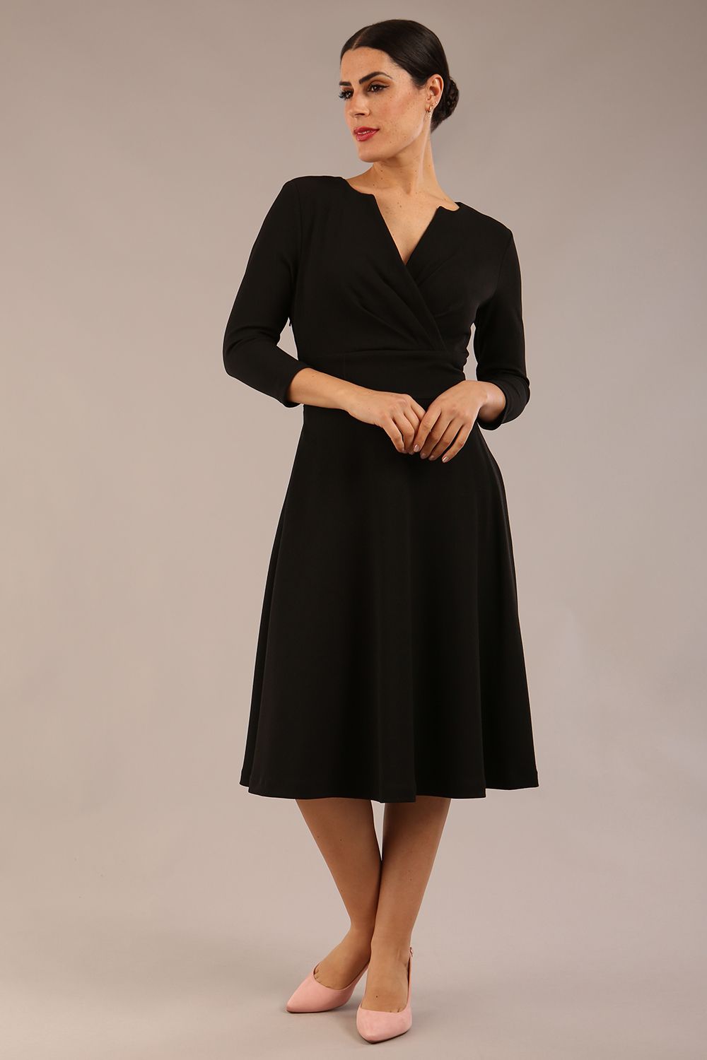 brunette model is wearing a diva catwalk january sleeved a-line swing v-neck dress in marvel fabric in black colour front 