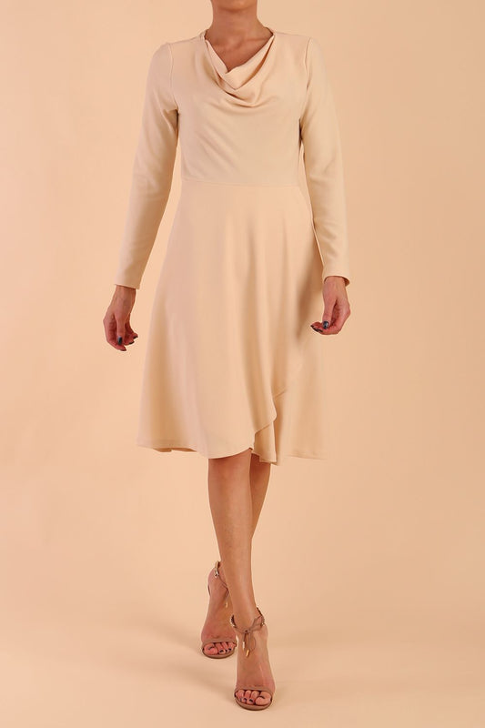 model is wearing diva catwalk moraig swing long sleeve dress with high cowl neckline and wrap skirt in beige front