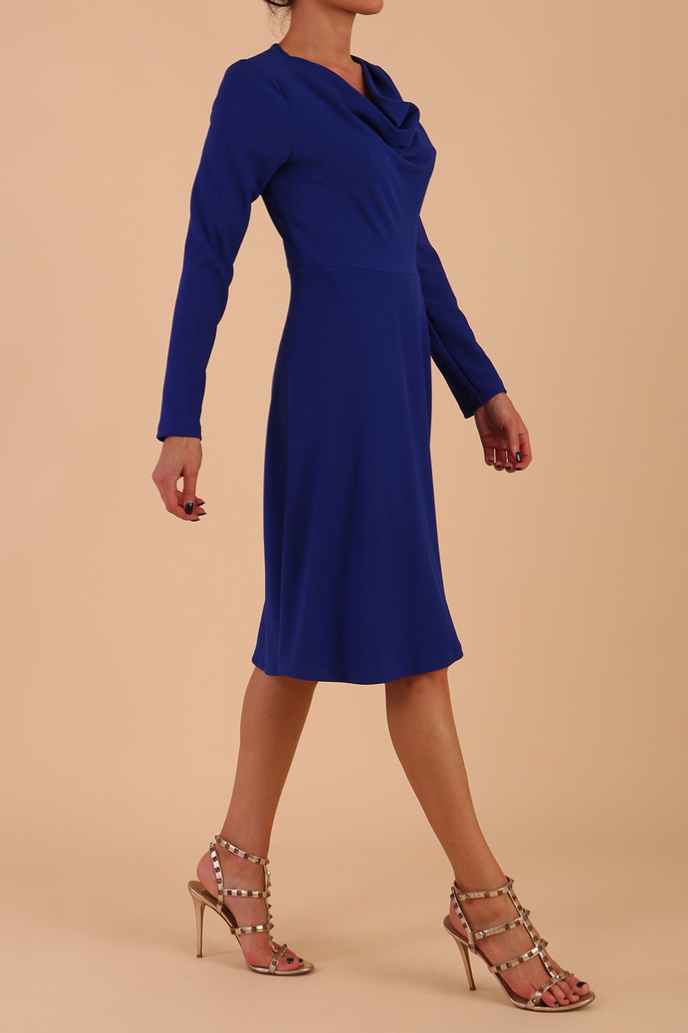 model is wearing diva catwalk moraig swing long sleeve dress with high cowl neckline and wrap skirt in cobalt blue front side